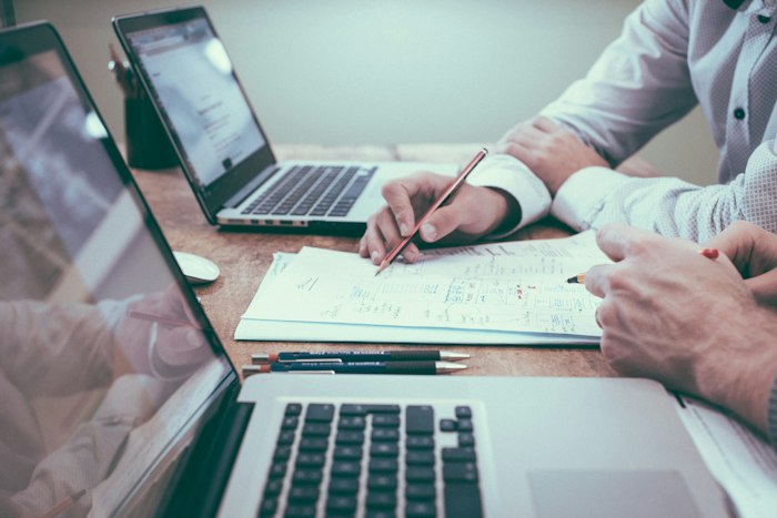 Professional reviewing insurance documents on laptop